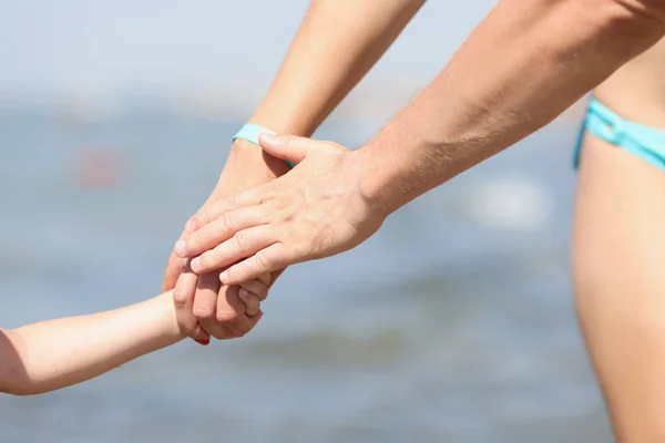 Család kéz a kézben, anya apa és gyermek sétál a tengerparton — Stock Fotó