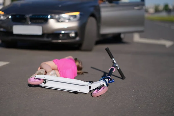 Niña en scooter golpeado en la carretera por automóvil, accidente de tráfico — Foto de Stock