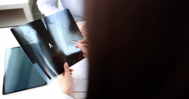Ο γιατρός εξετάζει μια ακτινογραφία του ασθενούς με σπασμένο χέρι — Αρχείο Βίντεο