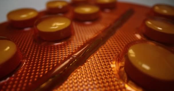 Medische witte pillen in een oranje blister — Stockvideo