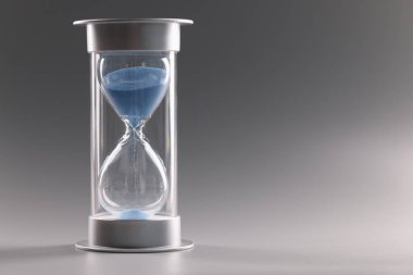 Küçük bir delikten akan mavi kumla dolu kum saati.