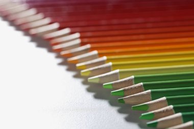 Renkli kalemler beyaz yüzeyde mükemmel bir sıraya dizildi