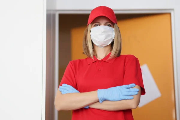Mulher de uniforme vermelho usar máscara protetora e luvas — Fotografia de Stock