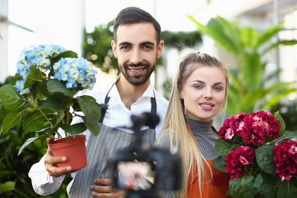 Young woman and man posing for picture with luxury bouquets of flowers — Stock Photo, Image