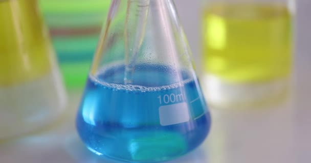 Substance is taken from flask with blue liquid with pipette — Stock Video