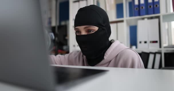 Fraudster in balaclava holds magnifying glass searches Internet gullible users — Stockvideo