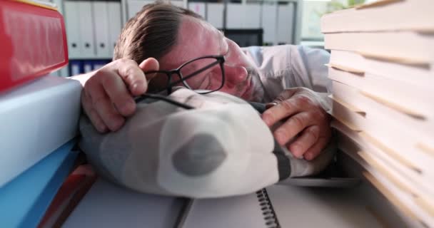 Homme d'affaires avec des lunettes à la main dormant sur l'oreiller parmi les documents 4k film ralenti — Video