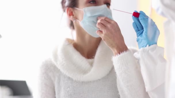 Медсестра в защитном костюме берет мазок ПЦР из носа пациентки 4К фильма замедленной съемки — стоковое видео