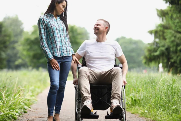 Mannen sitter i rullstol, kvinnan tillbringar tid med vännen på vårdhemmet — Stockfoto