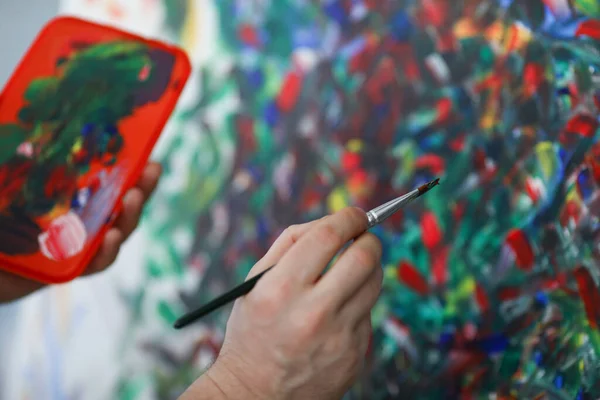 Artiste appliquer peinture à l'huile sur toile, peintre utiliser pinceau avec de la peinture rouge, outil pour la peinture — Photo