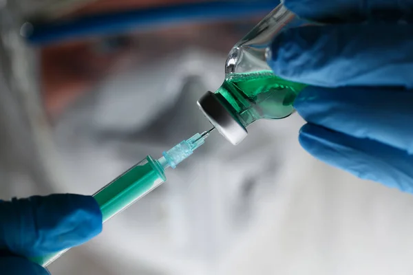 Scientist holding injection needle in hands in blue gloves — 图库照片