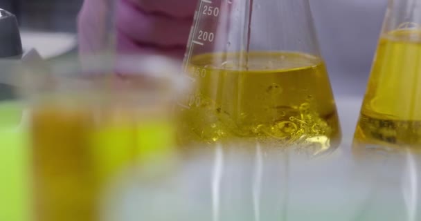 Químico cientista derramando líquido em frasco com óleo de motor em laboratório closeup filme 4k câmera lenta — Vídeo de Stock