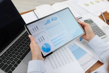 Ofisteki tablette dijital kağıtları inceleyen işçiler