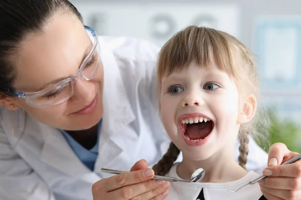 Barn besöker husläkare, barnläkare med verktyg kontrollera halsen, flicka öppna munnen vid — Stockfoto