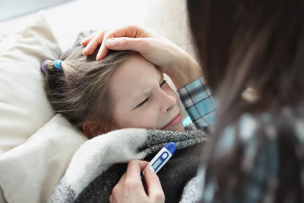 Sick girl stay in bed, mother measure temperature with electronic thermometer — Foto Stock