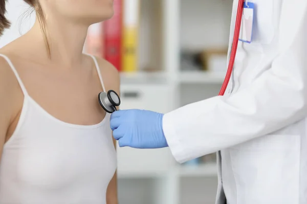 Жінка-лікар слухає груди пацієнта за допомогою інструменту стетоскопа — стокове фото