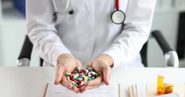 Doktor elinde çok renkli tıbbi haplar tutuyor.