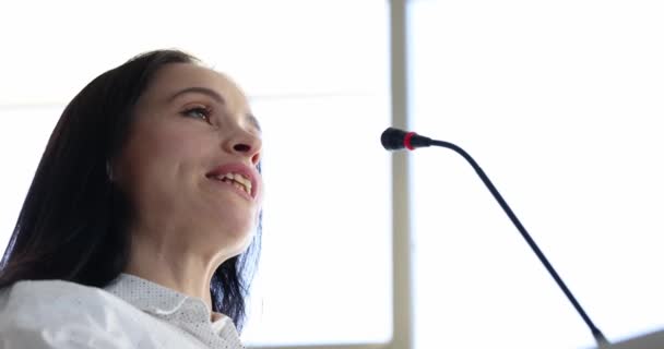 Retrato de la joven oradora hablando en el micrófono — Vídeos de Stock