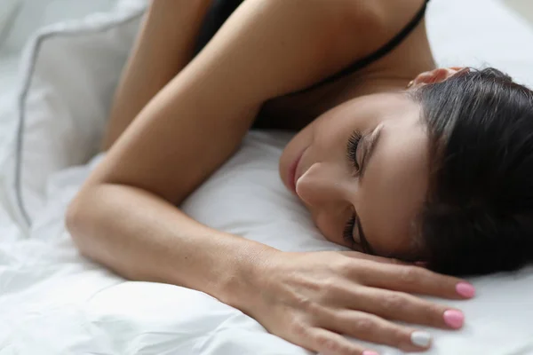 Giovane donna che dorme in bianco comodo letto — Foto Stock