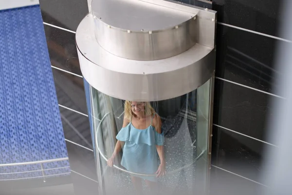 Hermosa mujer en el ascensor de cristal del edificio —  Fotos de Stock