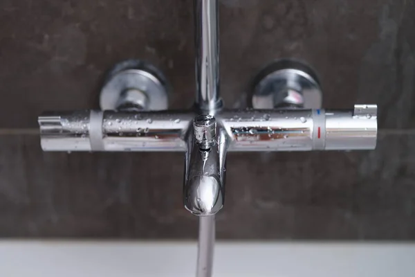 Gouttes d'eau sur le mélangeur mural dans la salle de bain — Photo