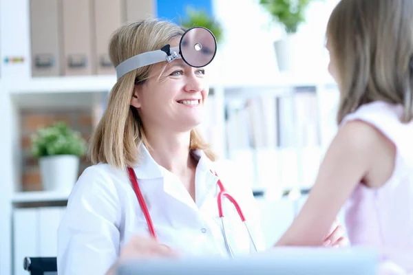 Femme médecin à la clinique souriant à la fille — Photo