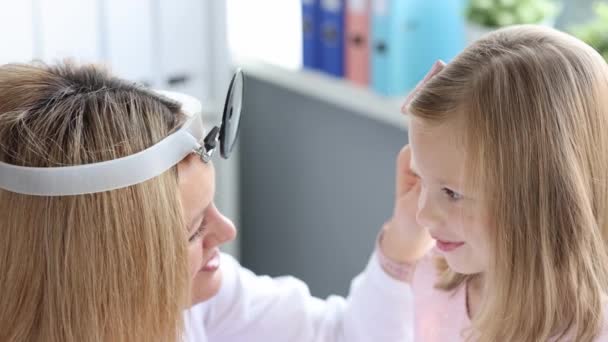 ENT doctor examining little girl ear using otoscope 4k movie slow motion — стоковое видео