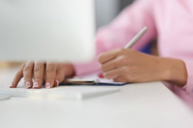 Person writing down ideas in journal on working place, making notes for future