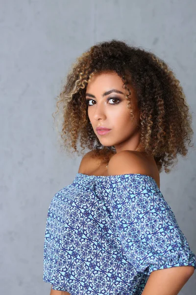 Pretty young woman with curly hairstyle posing in professional studio — стоковое фото