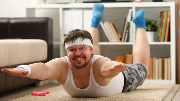 Man lies with excess weight doing exercises lying for spine at home — Fotografia de Stock