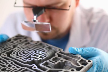 Car repair mechanic holds automatic transmission in hands