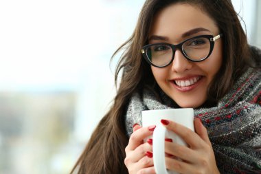 Beautiful girl is holding large cup in hands closeup
