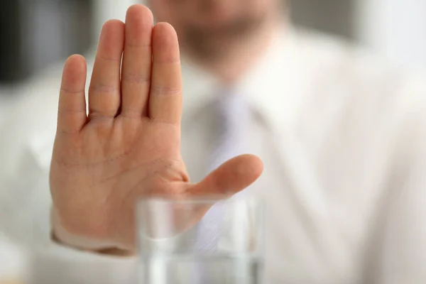 Male hand shows a negative gesture to glass beaker — Stock Fotó