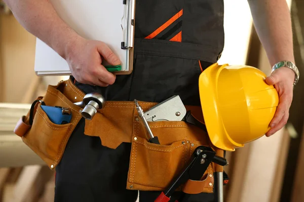 Cropped professional builder holding construction tools and helmet — Stockfoto