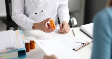 Doctor hands over jar of medicine to patient