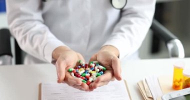 Doctor is holding many multi-colored medical drugs in hands
