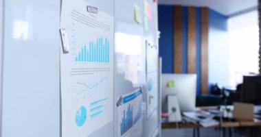 Manager attaches business statistics report to white board