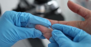 Laboratory technician drips human red blood onto glass for virus test