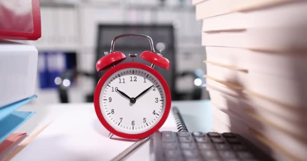 Κόκκινο ξυπνητήρι για δέκα oclock στην επιφάνεια εργασίας με έγγραφα — Αρχείο Βίντεο