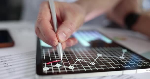 Marketer draws red line on business graphs on tablet — Vídeo de Stock