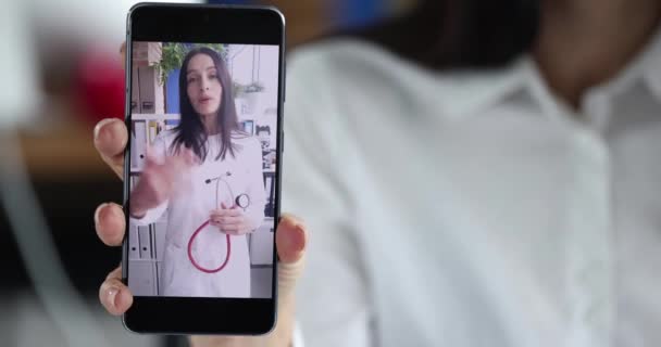 Mujer usando el teléfono móvil para hacer videollamadas con el médico. — Vídeos de Stock