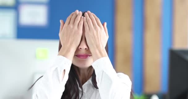 Young woman covers eyes with hands and shakes head. — Stok video
