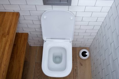 Clean toilet bowl in a wc with white tiles