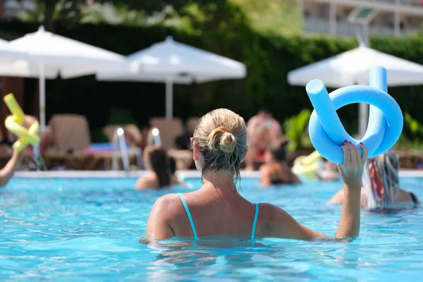 Woman in the pool doing exercises in aquafitness, back view — 스톡 사진