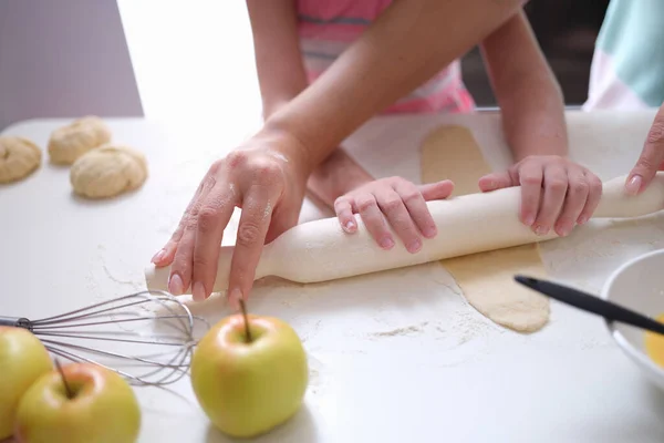 Mom and daughter roll out the dough with a rolling pin — Fotografia de Stock