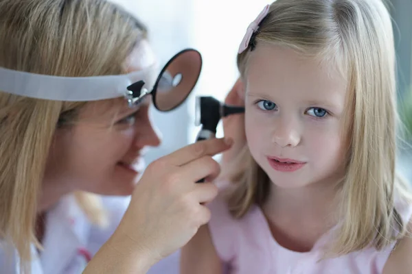 Симпатична маленька дівчинка дозволяє лікарю перевірити вухо, крупним планом — стокове фото