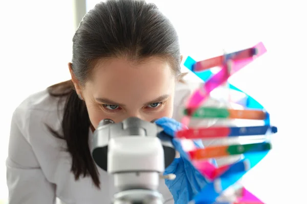 A woman biologist looks through a microscope, eyes close-up — Fotografia de Stock