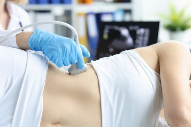 Doktor klinikteki hastaya ultrason yapıyor.