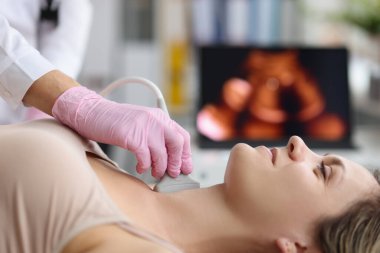 Doktor klinikteki kadın hastaya ultrason yapıyor.