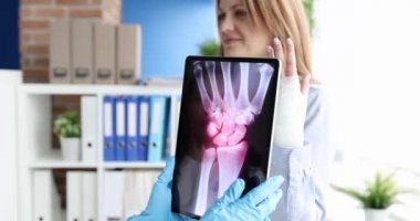 Doktor tableti hastanın elinin röntgeniyle tutuyor.